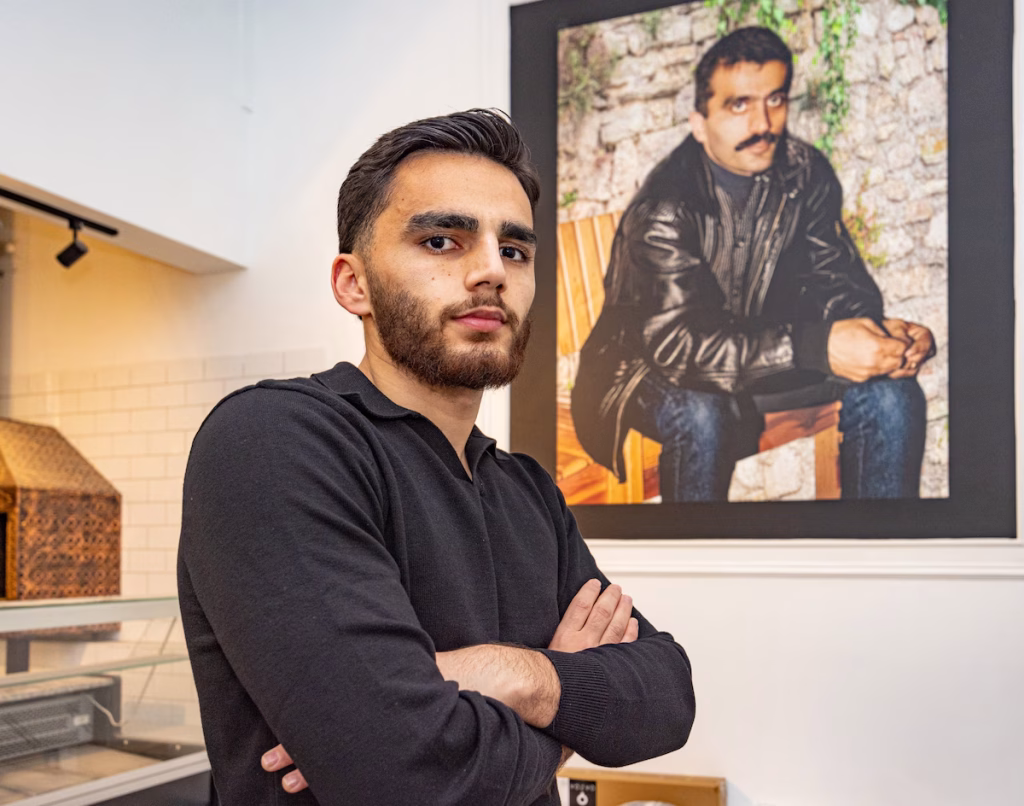 in de zaak van can hangt een grote foto van zijn overleden vader